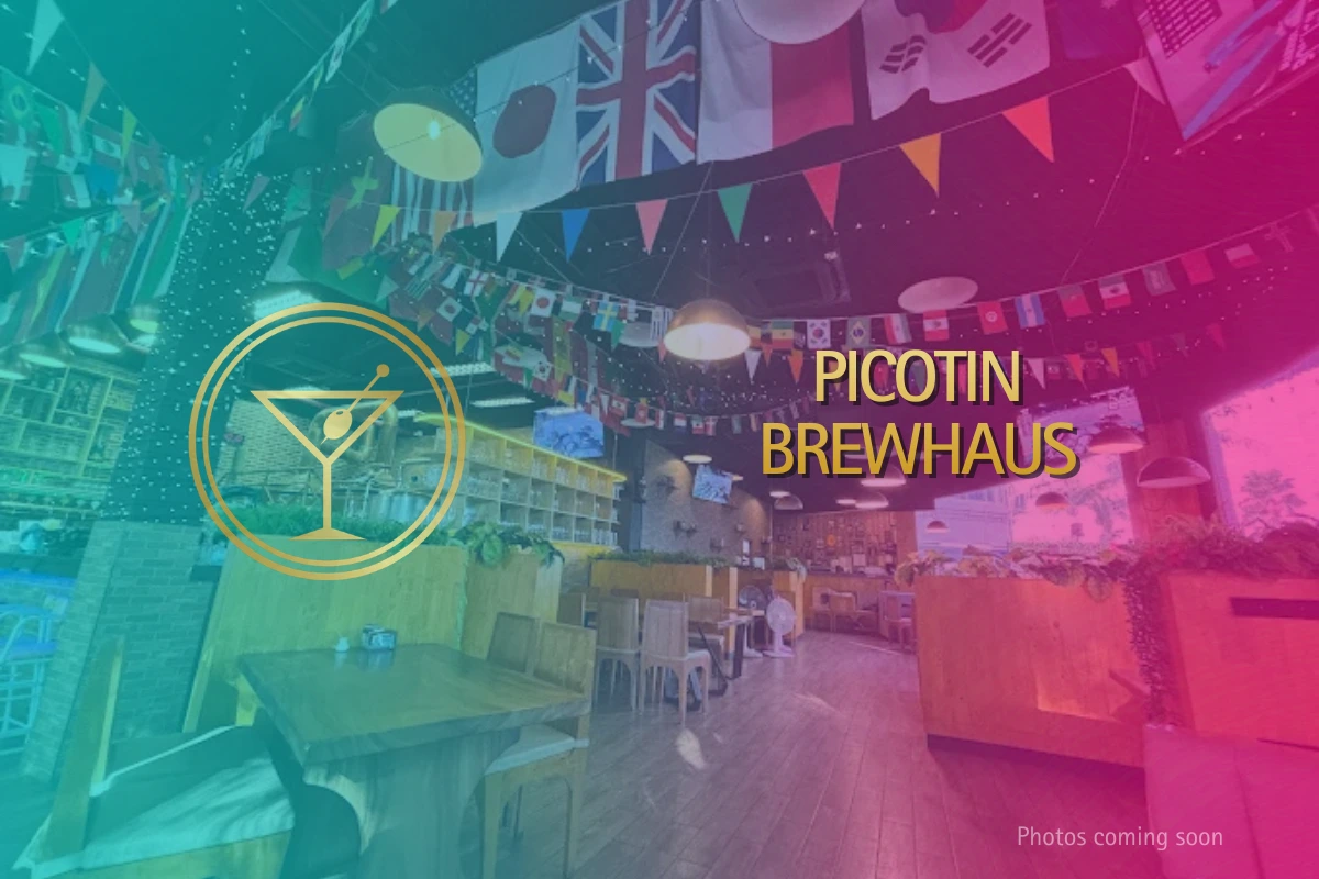 Picotin Brewhaus interior featuring wooden tables, international flags on the ceiling, and a spacious craft beer dining area.