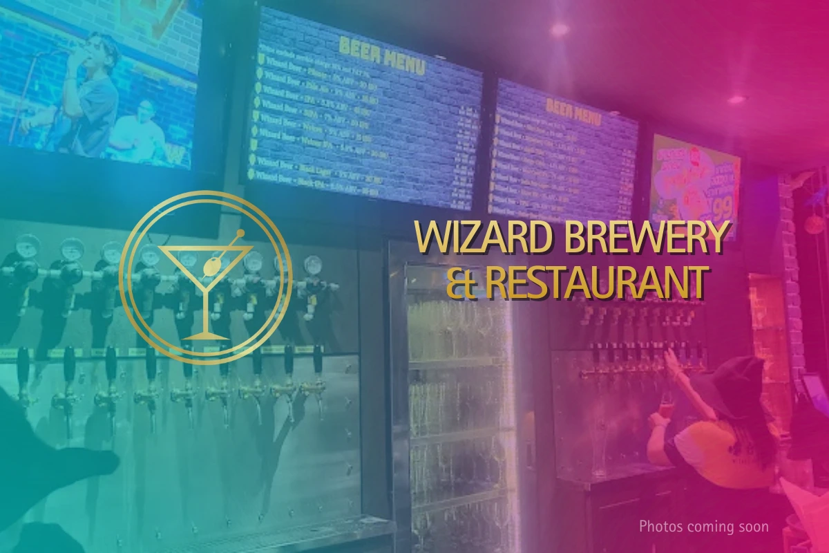 Interior of Wizard Brewery & Restaurant showing multiple beer taps, digital beer menus, and customers choosing craft beers.