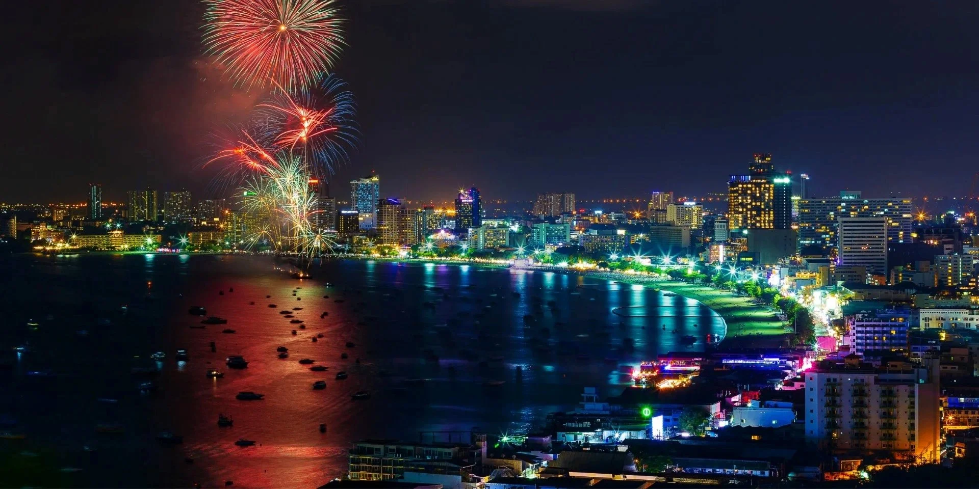 A stunning view of Pattaya Bay illuminated by fireworks and city lights — the perfect backdrop for exploring the best bars in Pattaya.